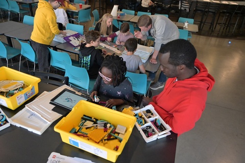 Students and adult helpers engaged in hands-on science activities.