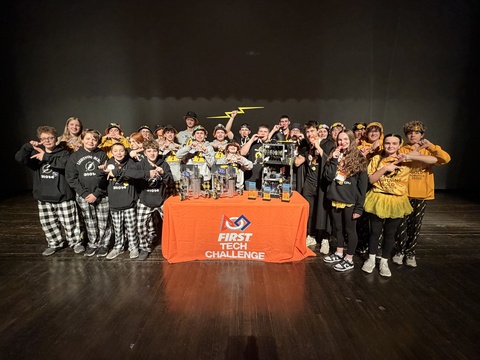 Students pose near robot