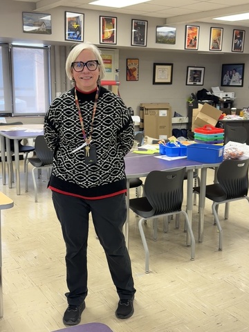 Woman stands posing for a picture in her classroom