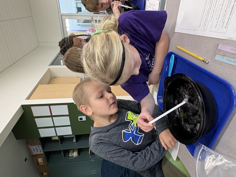 Two elementary-aged students engage in hands-on science activity