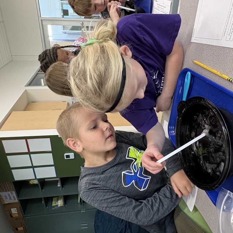 Two elementary-aged students engage in hands-on science activity