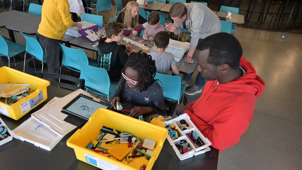 Students and adult helpers engaged in hands-on science activities.