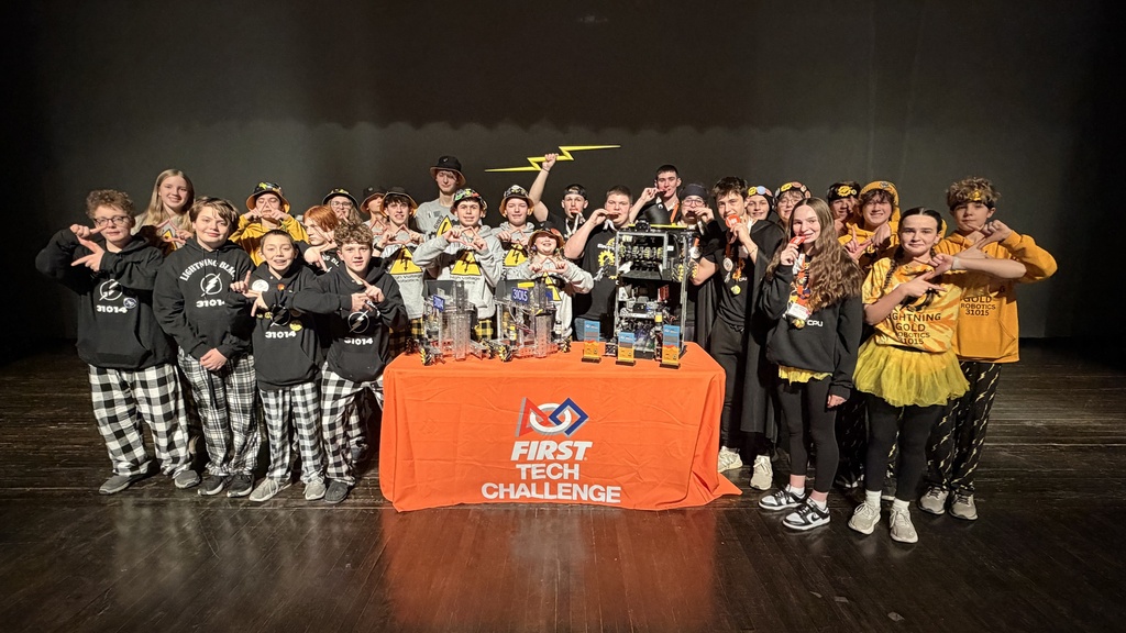 Students pose near robot