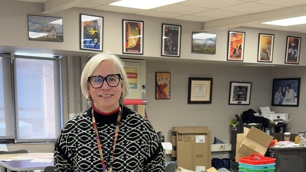 Woman stands posing for a picture in her classroom